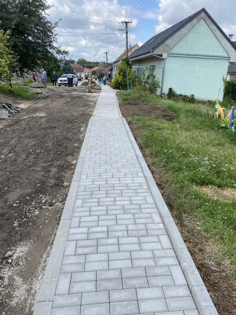 Nový dlážděný chodník podél ulice