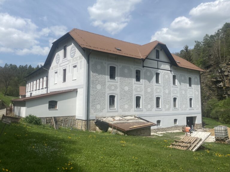 Boční pohled na historickou budovu s bílou fasádou