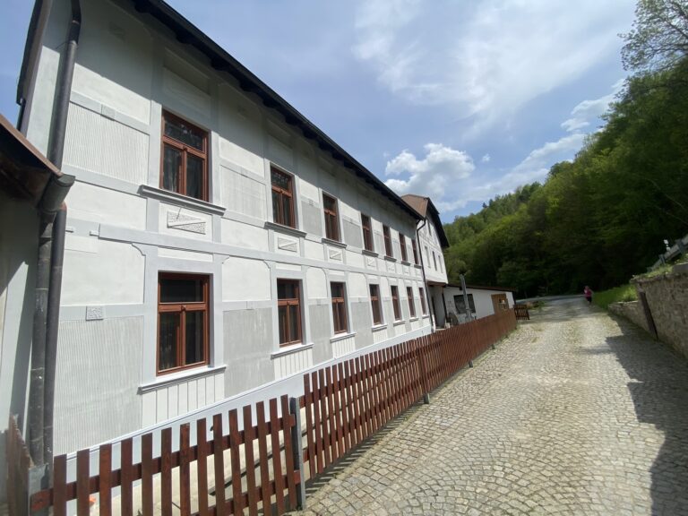 Dlouhá fasáda historické budovy podél cesty