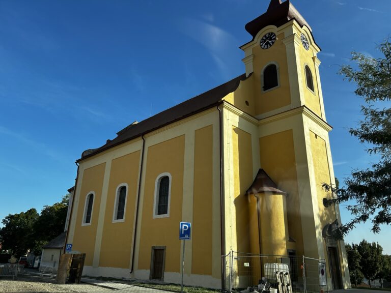 Kostel se žlutou fasádou a věží