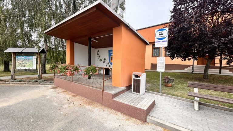 Krytý vstup do oranžové budovy a přilehlý chodník