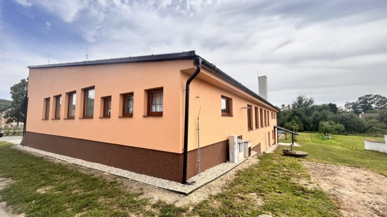 Boční fasáda oranžové budovy se soklem