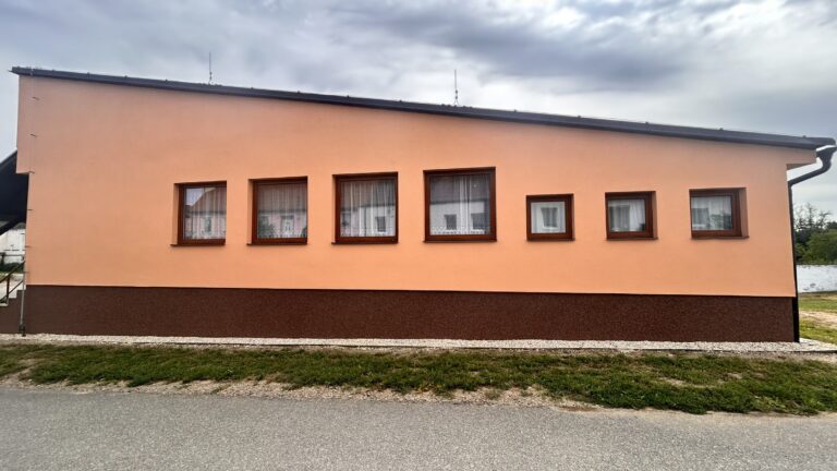Řada oken na oranžové fasádě