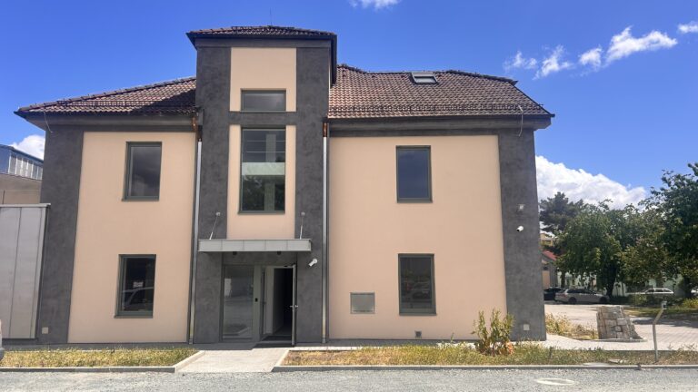 Čelní fasáda budovy s proskleným schodištěm